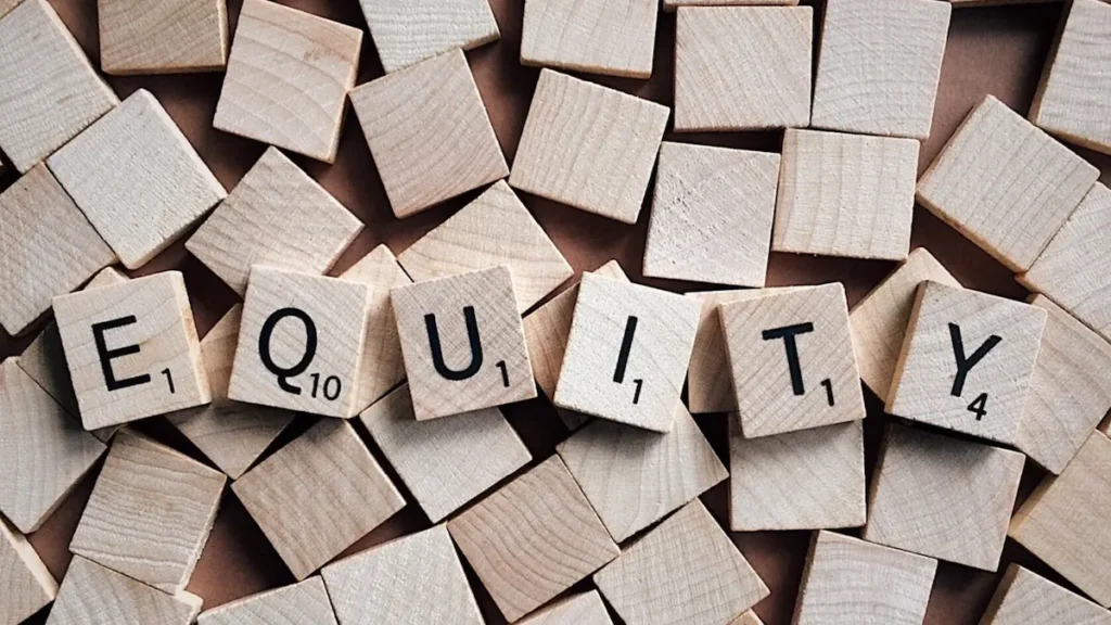 A bunch of wooden cubes, with the word EQUITY written on the ones on top