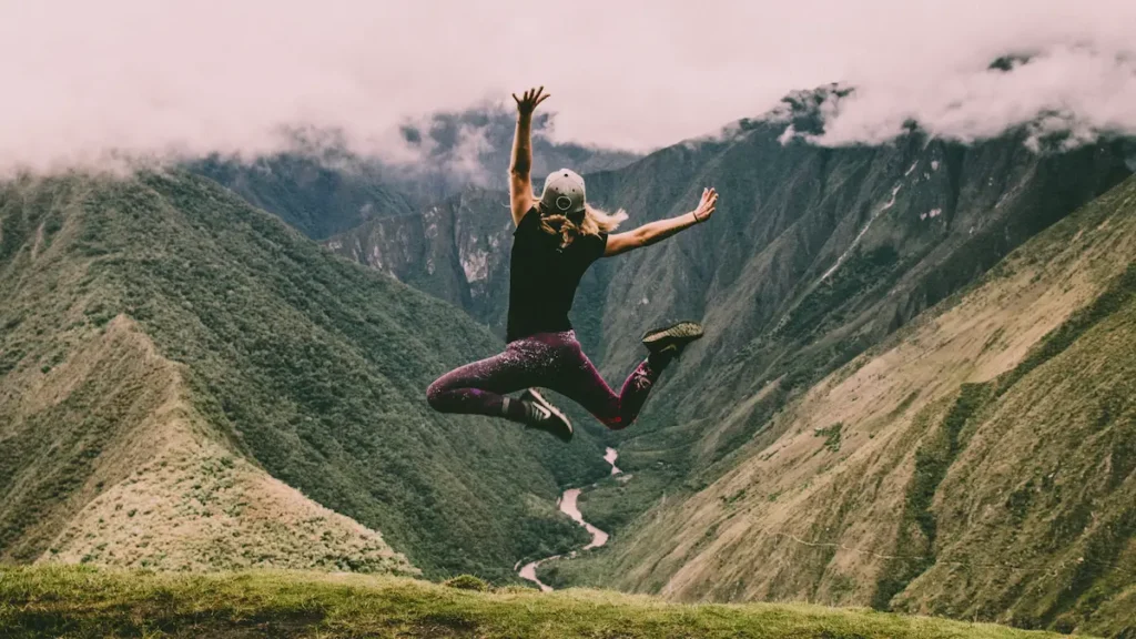 A person jumping in the air in the mountains