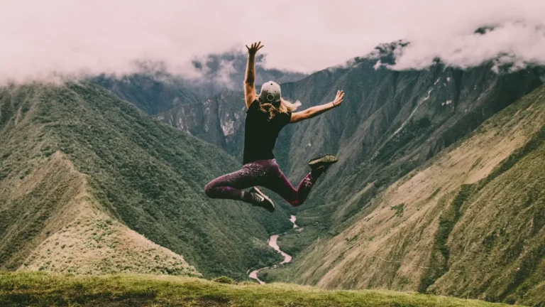 A person jumping in the air in the mountains